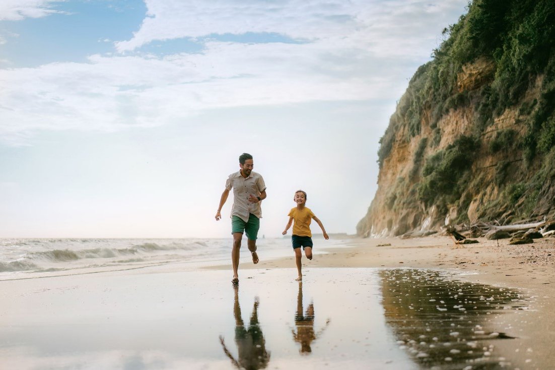 Father and daughter running on the beach
