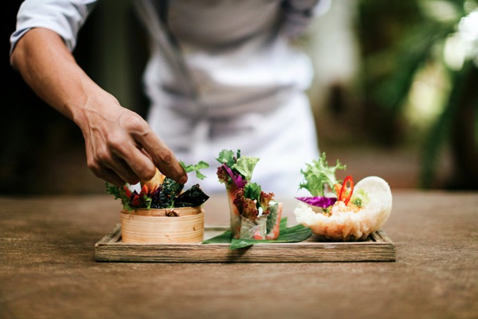 man garnishing a platter